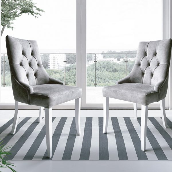 Imagen de dos sillas modelo 135 con acolchado gris y patas blancas.